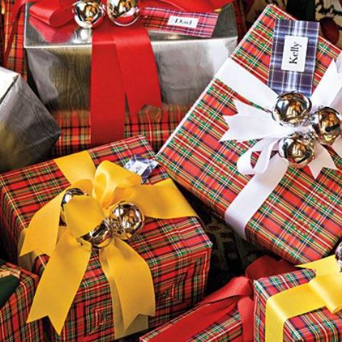 Christmas gifts wrapped in plaid paper, with yellow and white ribbon and silver bells on top are amazing for Christmas