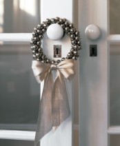 a wreath of silver bells and a silver bow is a lovely accent for your doorm, inner or outer