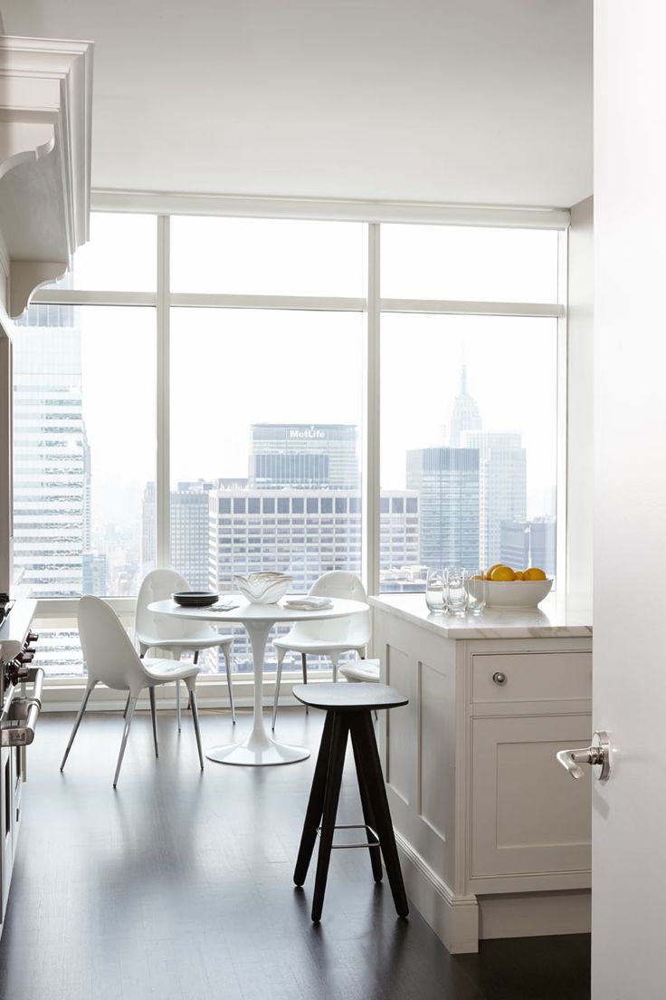 a modern white kitchen with a gorgeous view of the big city is a lovely light filled space to enjoy your meals