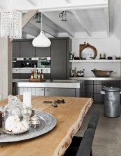 a fresh Nordic kitchen with grey cabinets and white surfaces, a live edge dining table and stylish pendant lamps