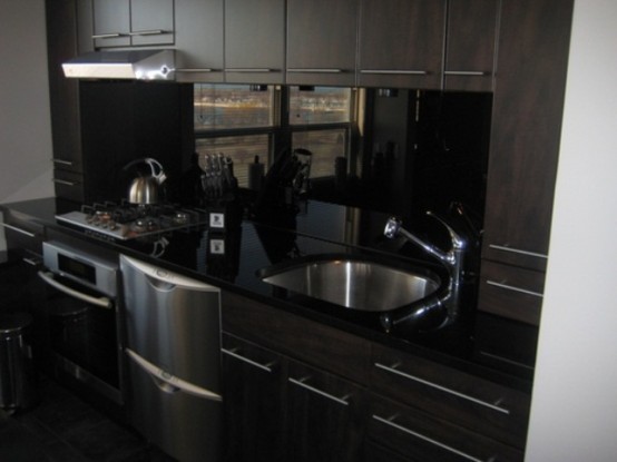 dark furniture and a sleek black backsplash and countertops look very masculine and very outstanding