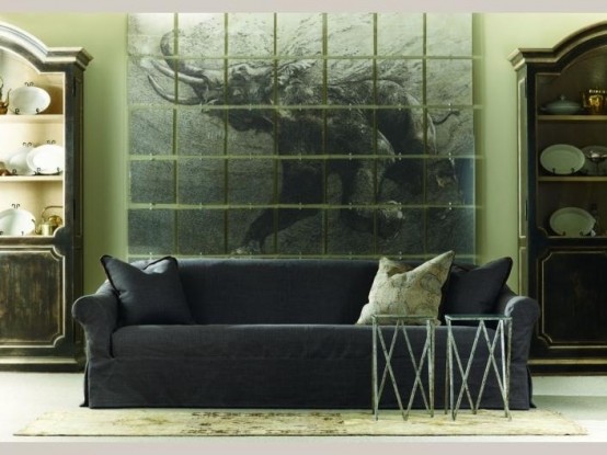 a dark living room with an oversized artwork, dark furniture and elegant armoires with plates on display
