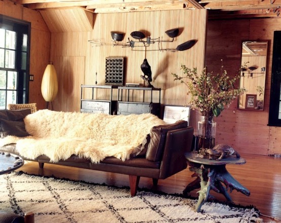 a cozy masculine living room with wooden walls, leather and dark wooden furniture, wooden tables and metal lamps