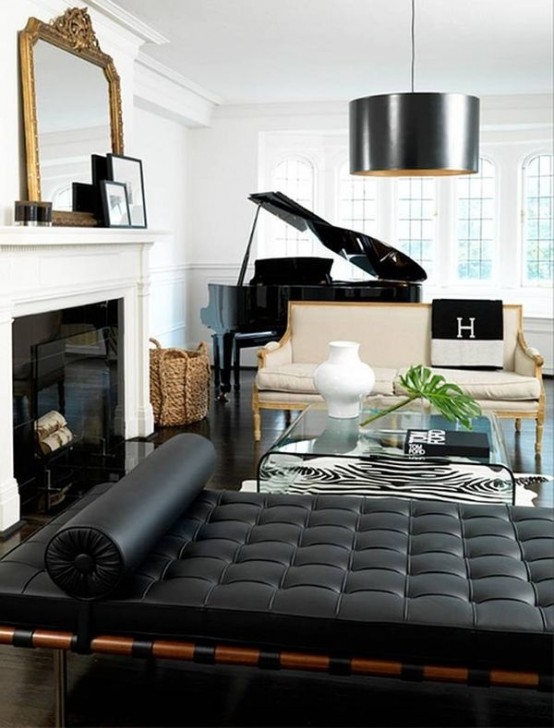 a sophisticated living room done in black and white, with refined furniture and a piano, lamps and a mirror plus a fireplace