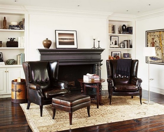 a sophisticated living room with all neutrals, dark leather furniture, a dark fireplace plus built-in storage units