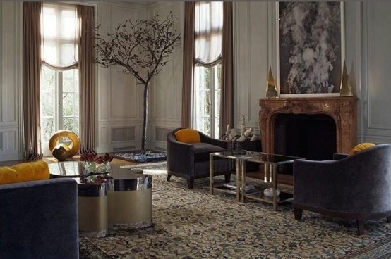 a refined living room with elegant furniture, gilded touches, a fireplace, a large artwork and curtains