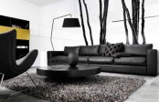 a minimalist masculine living room with dark furniture, a round coffee table, a floor lamp and a bright storage unit