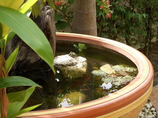 an oversized striped bowl pond with rocks, some greenery and water lilies is a lovely idea for a modern space
