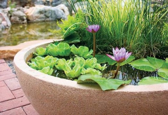 a light-colored stone plaster as a pond, with greenery, grasses and bright pink blooms for beautiful outdoor decor