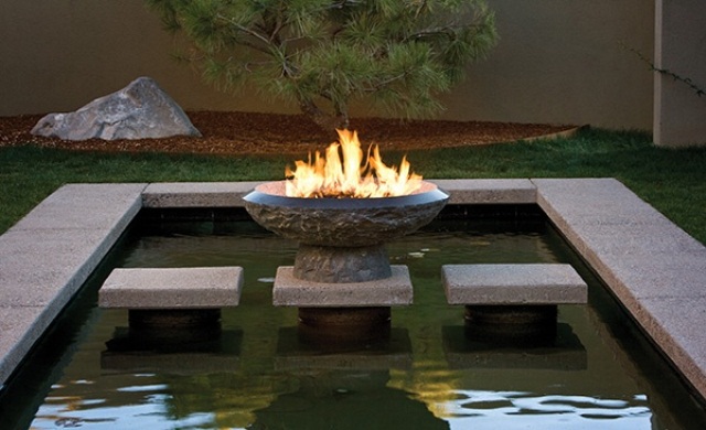 a lovely backyard pond with a firebowl
