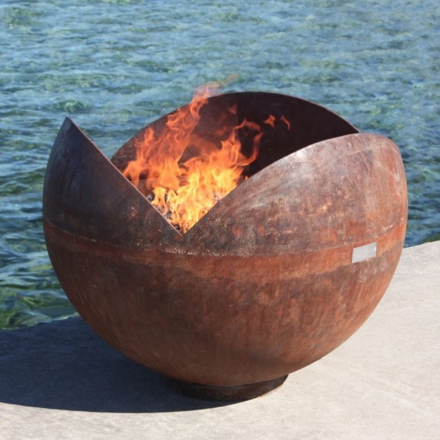 a spheric metal fire bowl looking as if its petals are opening is a great idea for a modern outdoor space, its look is simple and catchy