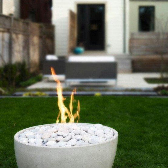 a modern laconic white stone fire bowl filled with white pebbles and using alcohol for working is great for modern and contemporary spaces