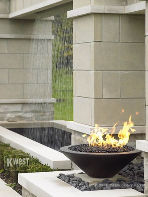 a black stone fire bowl filled with black pebbles and working on alcohol is a great idea for a modern and laconic outdoor space