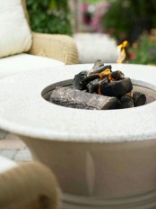 a classic neutral stone fire bowl with a countertop to place a glass of wine or s’mores here always works for a mid-century modern outdoor space