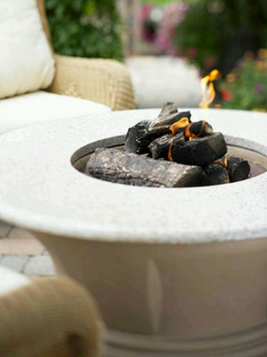 a classic neutral stone fire bowl with a countertop to place a glass of wine or s'mores here always works for a mid-century modern outdoor space