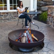 a classic metal fire bowl on a low stand is a great idea for most of modern outdoor spaces