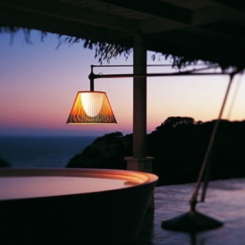 a jacuzzi with a sea view is a perfect spot to relax in, a floor lamp adds coziness to the space