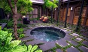 a jacuzzi with rocks around and with a tropical inner yard, with greenery and trees is a lovely idea for feel relaxed