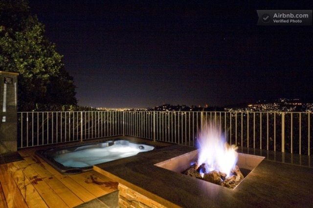 a deck with a built in jacuzzi and a fire pit, with a view of the city is a fantastic place to relax after a long day, it looks cool