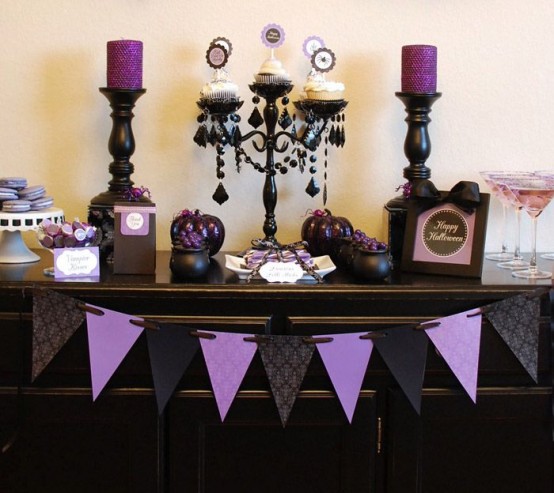 an elegant vintage black and purple Halloween sweets table with candles, cupcakes, sweets, candles and buntings is a very cool and fresh solution