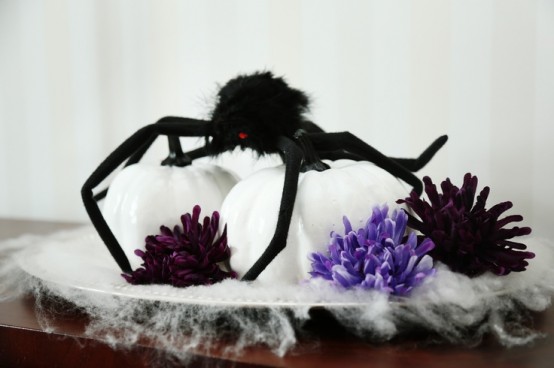 white pumpkins with lilac and deep purple blooms plus a black spider on top for creative and very cool Halloween decorating