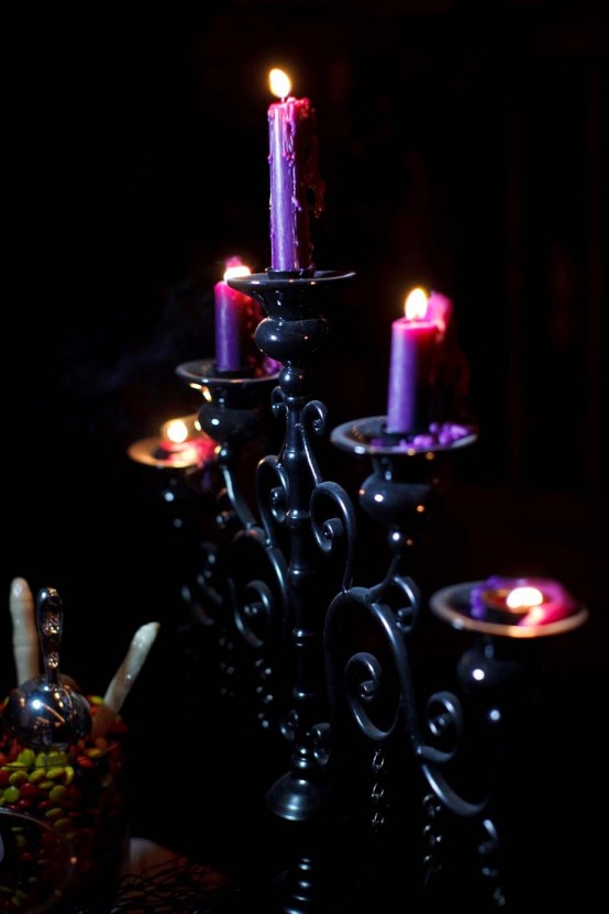 a refined black candelabra with purple candles is a very chic and gorgeous decoration for Halloween to add some drama to the space