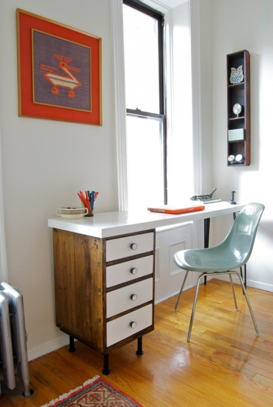 a modern rustic home office with a mid-century modern desk, a blue chair, a bright artwork and a shelving unit on the wall