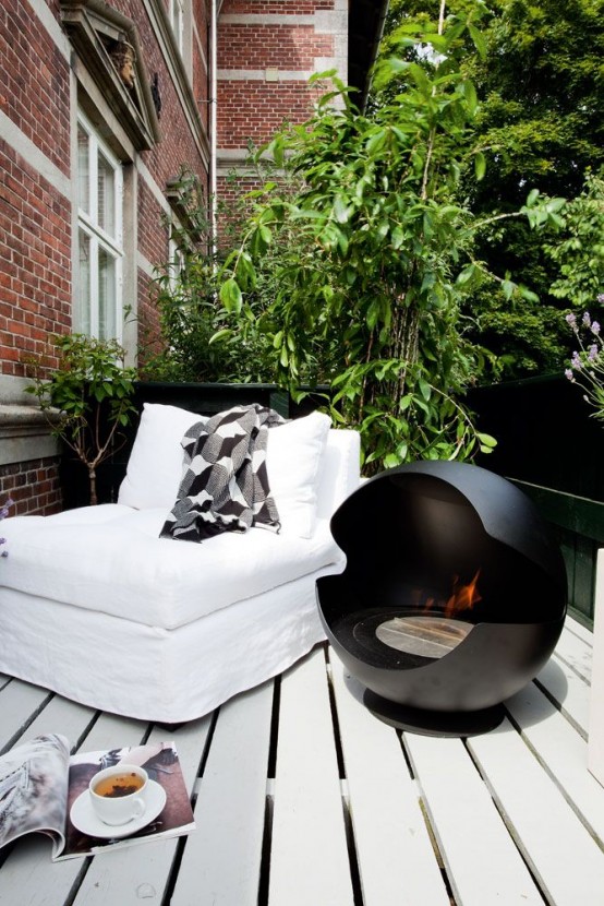 a Nordic balcony with a white lounger, a black open fireplace, lots of greenery around is amazing and relaxing