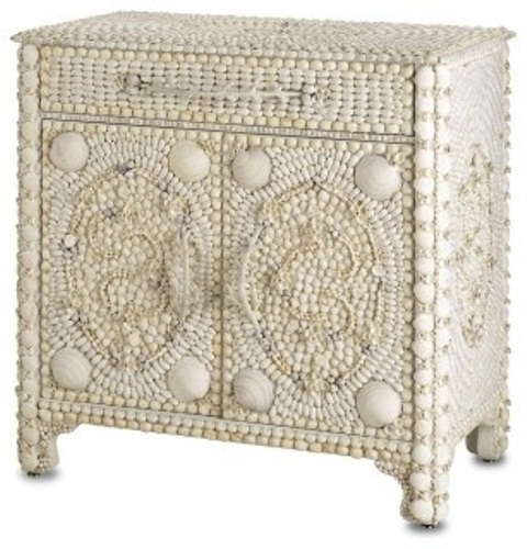 a white sideboard fully covered with seashells and pebbles in white looks very refined and very unusual