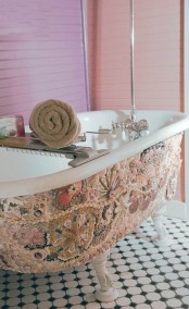a white clawfoot tub clad with pebbles, corals and seashells looks very eye-catchy and very beautiful