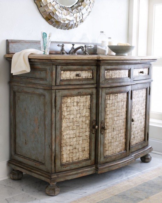 a vintage vanity clad with mother of pearl and a matching mirror for a beautiful sea-inspired bathroom