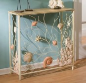 a catchy delicate console table with seashells, starfish and corals in natural colors for a beautiful seaside entryway