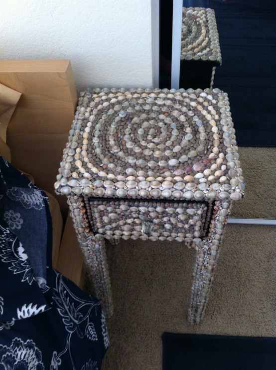 a small nightstand clad with seashells and pebbles is a nice solution for a modern seaside-inspired space