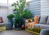 a contemporary small terrace with bright yellow furniture and grey upholstery plus lots of greenery potted
