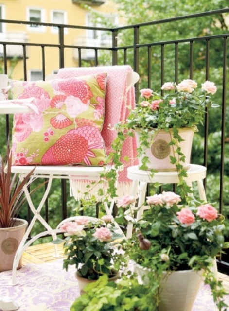 potted blooms and matching blankets and pillows make the balcony fresh, colorful and springy