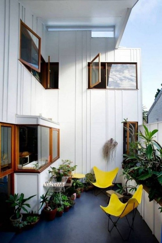 lots of potted greenery and sunny yellow chairs will make your balcony fresh and inviting