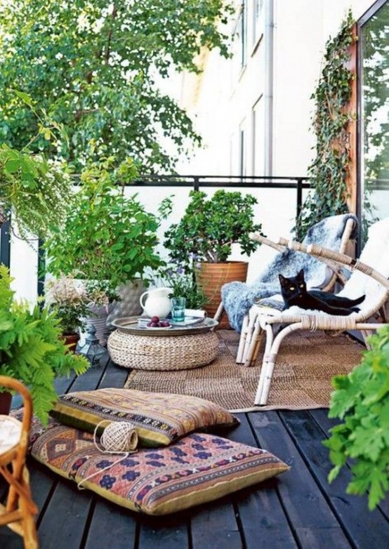 lots of greeneryin baskets, boho rugs and cushions, jute rugs and ottomans and a rattan chair for a boho feel
