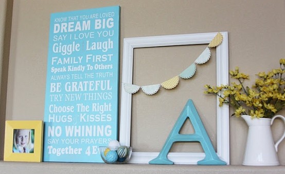 a bright summer mantel in blue and yellow, with a blue sign, a letter, pastel garland and a family photo
