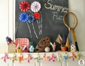 a summer fun mantel with a chalkboard, bird houses, planters, jars, baseball items and a colorful garland