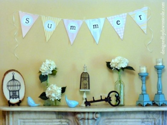 a vintage summer mantel with candles, blooms in vases, a banner, vintage keys and cage decor