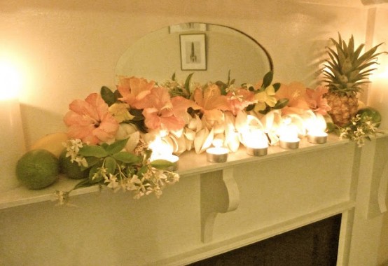 a tropical summer mantel with blush blooms, tropical fruits and candles