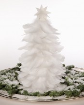 a white feather Christmas tree topped with a white star is a lovely idea for a neutral holiday space