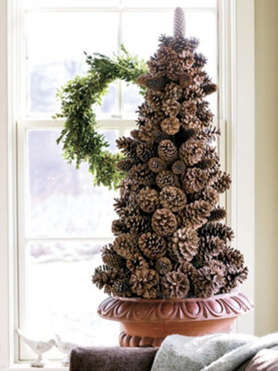 a cone-shaped pinecone Christmas tree in a planter is a lovely holiday decor idea that will bring a rustic or woodland feel to the space