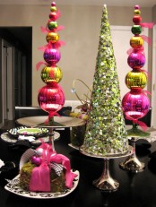 a super bold green sequin covered cone-shaped Christmas tree and pink, yellow and green ornament cone-shaped trees