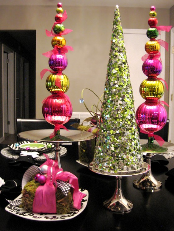 a super bold green sequin covered cone-shaped Christmas tree and pink, yellow and green ornament cone-shaped trees