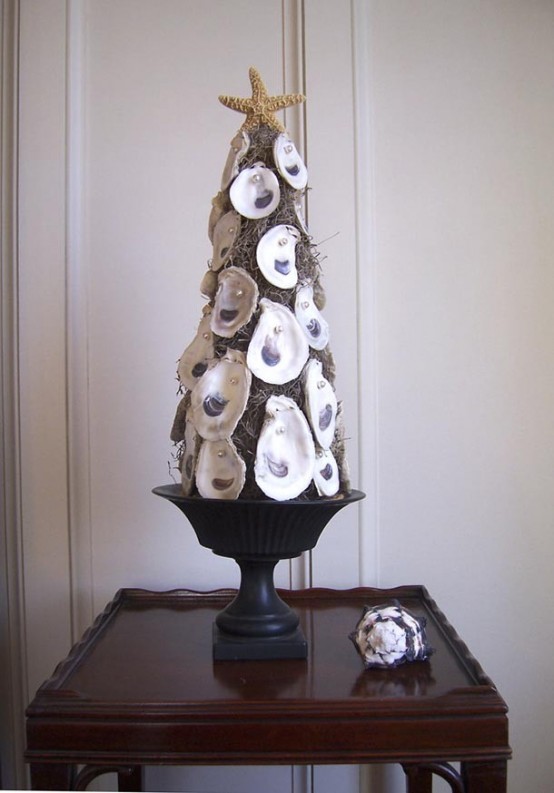 a hay tabletop Christmas tree clad with seashells with pearls and topped with a star is a lovely idea for a coastal Christmas space
