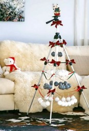 a white frame Christmas tree with black and white ornaments suspended and red bows plus a mini Santa on top is a super creative idea for any holiday space
