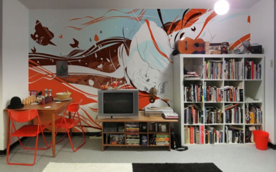 a colorful abstract wall mural matches a boy's bedroom and colorful stuff in it echoes with the mural