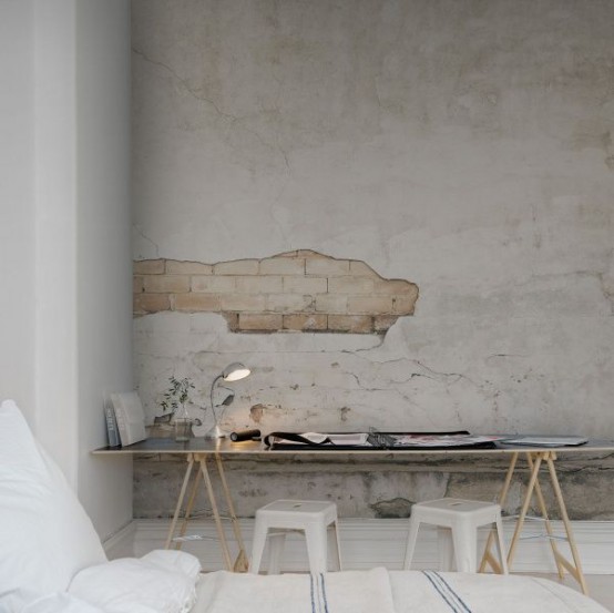 a simple and contemporary space done in neutrals with a catchy wall mural - a textural wall with a brick touch