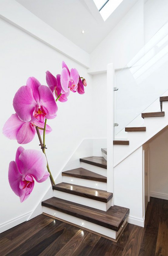 a very laconic space with white walls and a dark stained staircase plus a bright orchid wall mural to add color